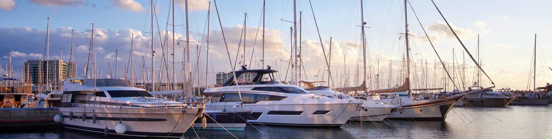 מרינה בהרצליה בשעת בין ערביים עם יאכטות מפוארות עוגנות לצידי המזח