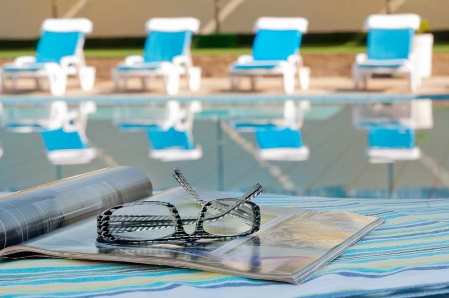 מלון לאונרדו קלאב טבריה עם בריכת שחייה גדולה עם מתנפחי בריכה ברקע 